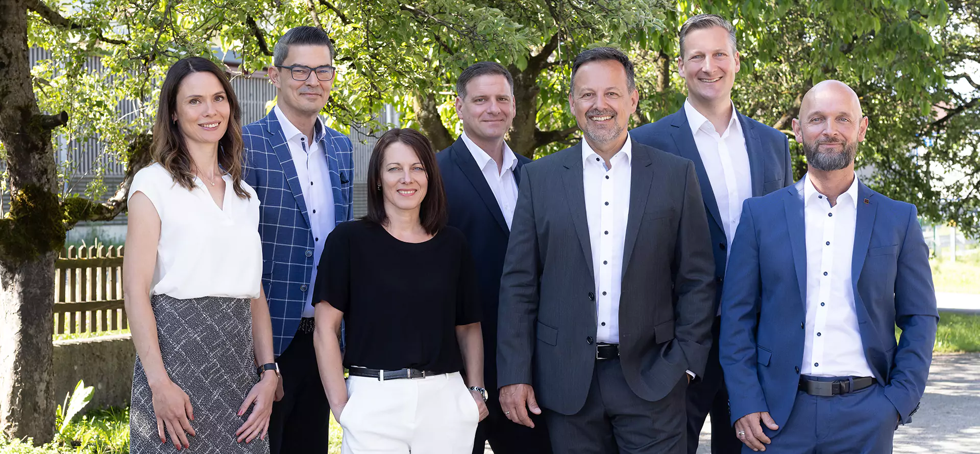 Gruppenbild vor begrüntem Hintergrund.