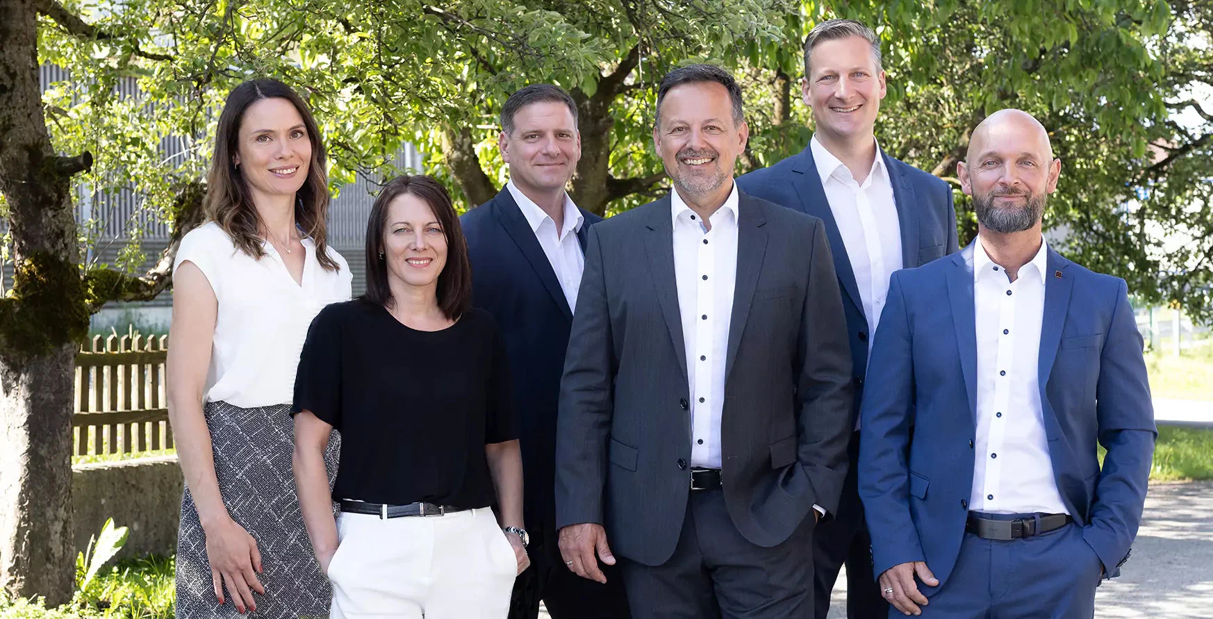Gruppenbild vor begrüntem Hintergrund.